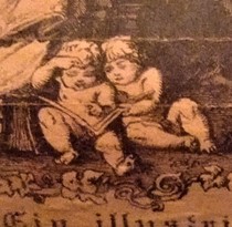 close up of two cherubs sitting side by side reading a book
